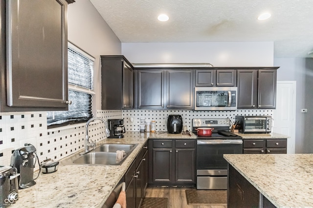 kitchen with sink, dark wood-type flooring, dark brown cabinets, and stainless steel appliances