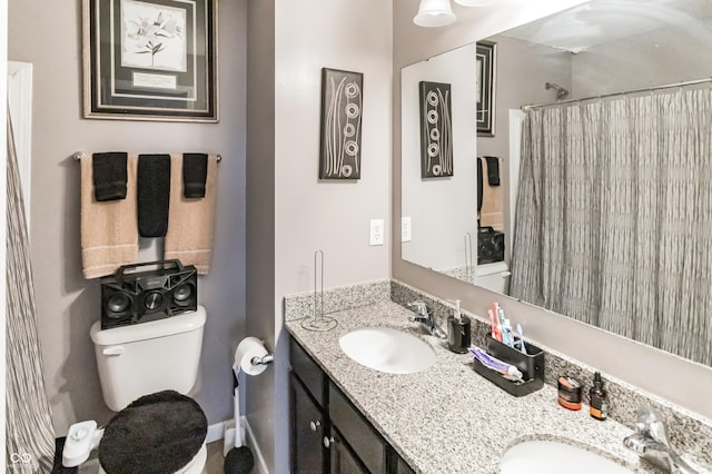 bathroom featuring vanity, curtained shower, and toilet