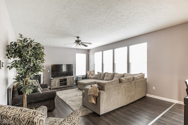 living room featuring ceiling fan, dark hardwood / wood-style floors, and a textured ceiling