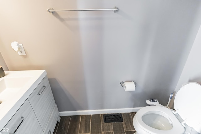 bathroom featuring hardwood / wood-style flooring, vanity, and toilet