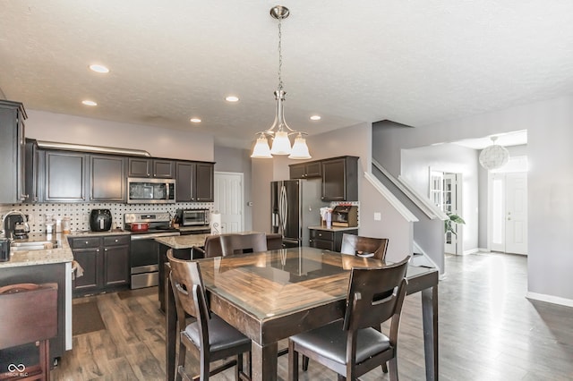 dining space featuring dark hardwood / wood-style flooring, sink, and a textured ceiling