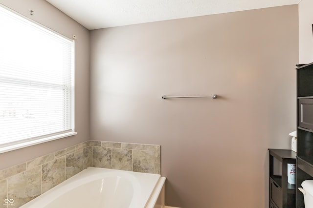 bathroom with a washtub and toilet