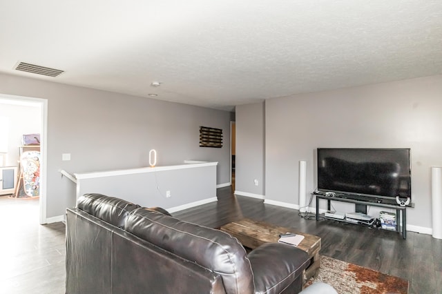 living room with dark wood-type flooring and a textured ceiling