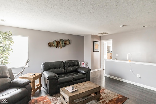 living room featuring dark hardwood / wood-style flooring and a textured ceiling