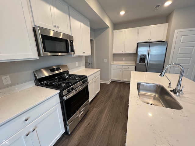 kitchen featuring appliances with stainless steel finishes, sink, white cabinets, and light stone counters