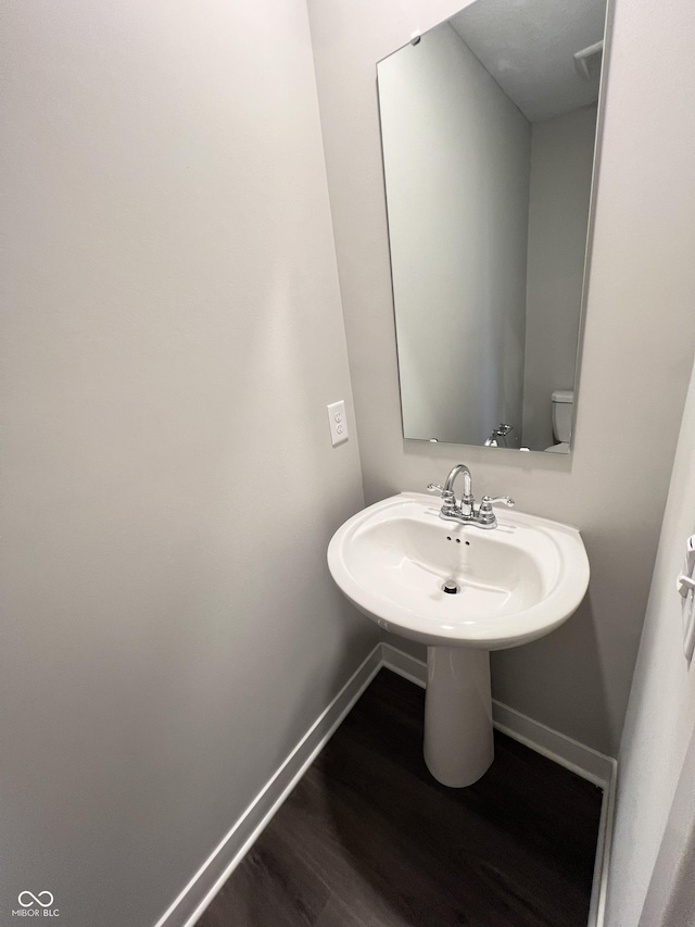 bathroom featuring wood-type flooring and toilet