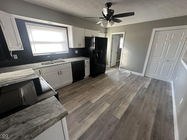 kitchen featuring sink, wood-type flooring, black appliances, white cabinets, and decorative backsplash