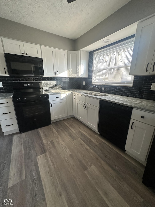 kitchen with sink, dark wood-type flooring, black appliances, white cabinets, and decorative backsplash