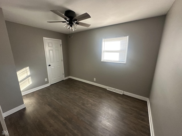 empty room featuring dark wood-type flooring and ceiling fan