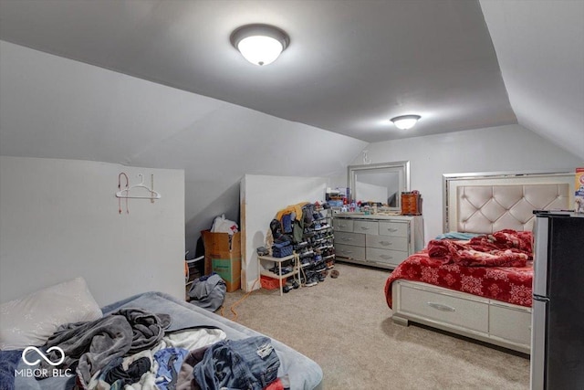 bedroom featuring vaulted ceiling, light carpet, and stainless steel fridge