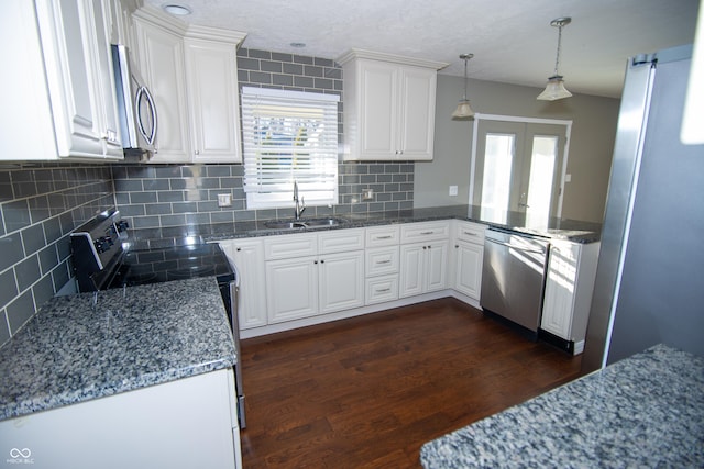 kitchen featuring sink, appliances with stainless steel finishes, white cabinets, dark hardwood / wood-style flooring, and decorative light fixtures