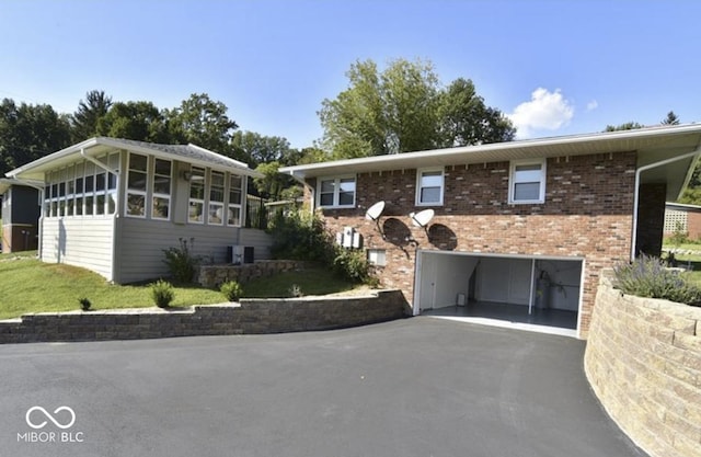 view of front of house featuring a garage and a sunroom