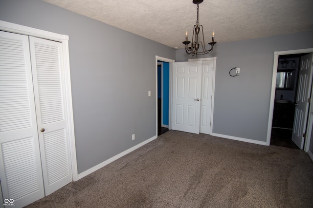 unfurnished bedroom featuring a chandelier, carpet, and a textured ceiling