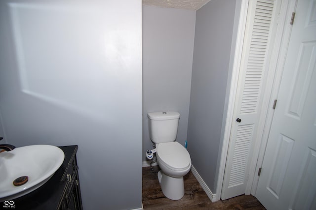 bathroom with vanity, wood-type flooring, and toilet