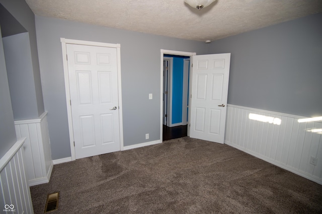 unfurnished bedroom with a textured ceiling and carpet flooring