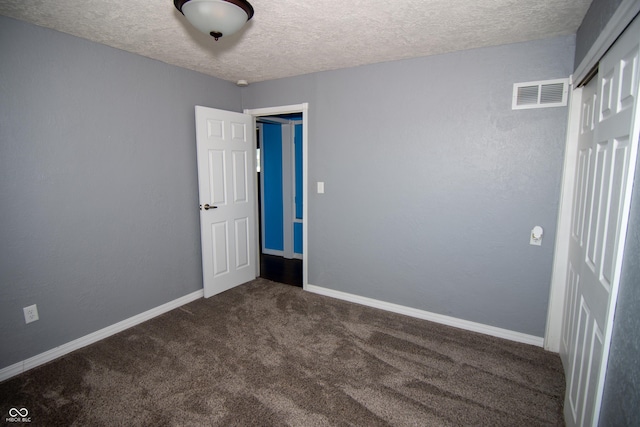 carpeted spare room featuring a textured ceiling