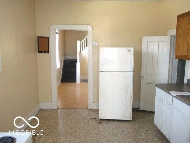 kitchen featuring white cabinetry and white fridge