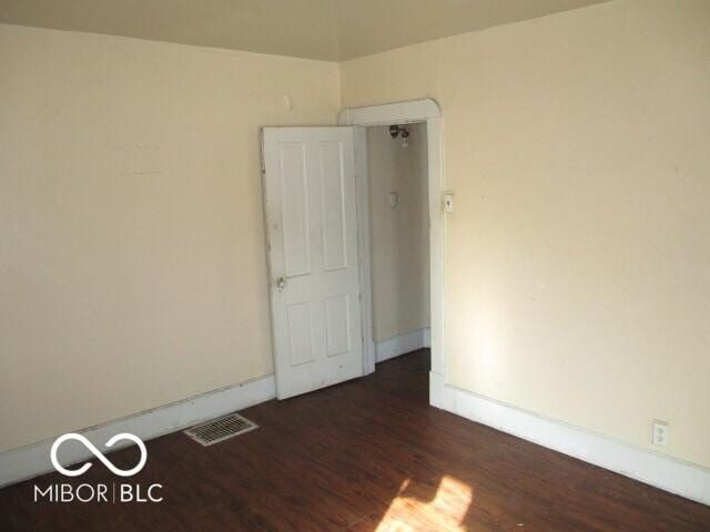 unfurnished room featuring dark wood-type flooring