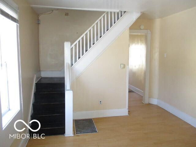 stairway featuring wood-type flooring and a healthy amount of sunlight