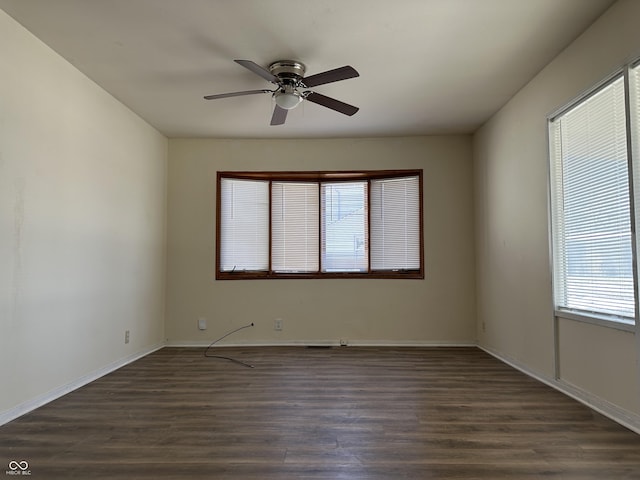 spare room with dark wood-type flooring and ceiling fan