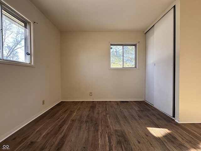 unfurnished bedroom featuring a closet and dark hardwood / wood-style floors