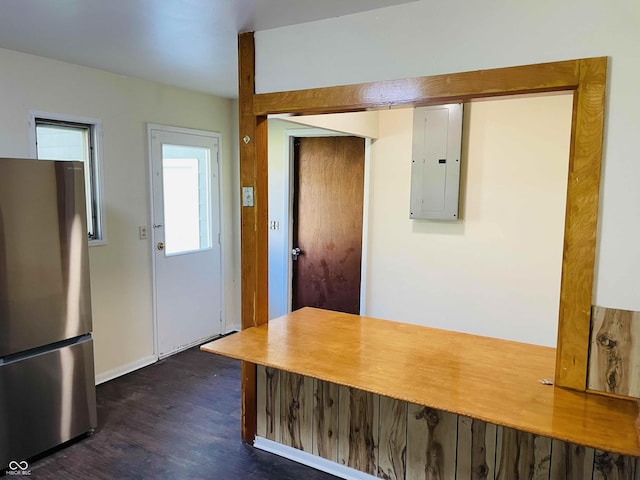 interior space featuring dark wood-type flooring, electric panel, and stainless steel refrigerator