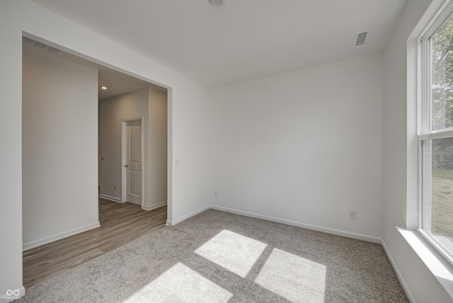 carpeted empty room with baseboards and visible vents