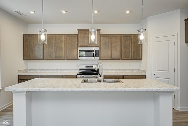 kitchen with appliances with stainless steel finishes, pendant lighting, and light countertops