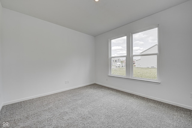 unfurnished room with carpet and baseboards