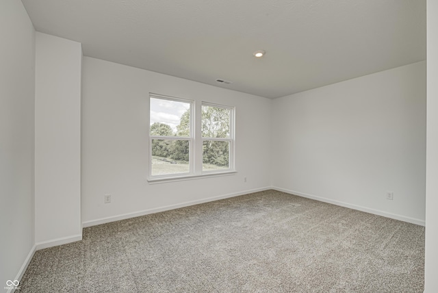 carpeted empty room featuring recessed lighting, visible vents, and baseboards