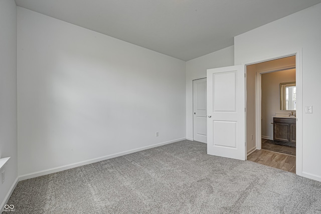 unfurnished bedroom with light carpet, vaulted ceiling, and baseboards