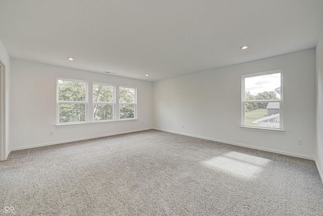 unfurnished room featuring carpet, plenty of natural light, and baseboards