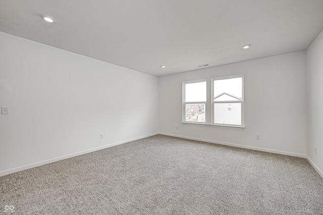 carpeted empty room with visible vents, baseboards, and recessed lighting