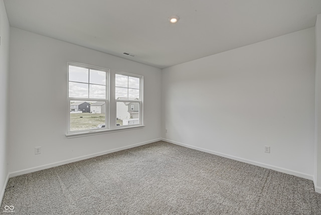 spare room with recessed lighting, carpet, visible vents, and baseboards