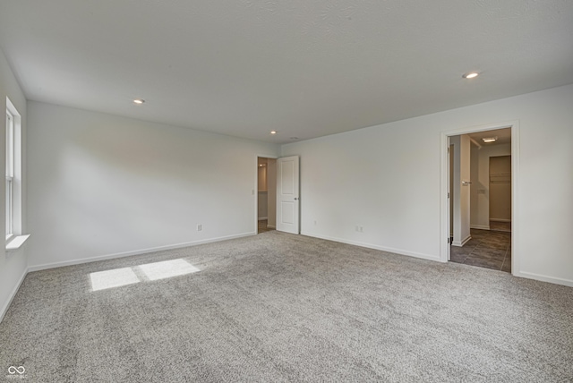 spare room featuring carpet floors, recessed lighting, and baseboards