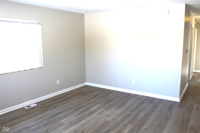 spare room featuring dark wood-type flooring