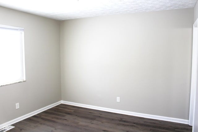 empty room with dark wood-type flooring