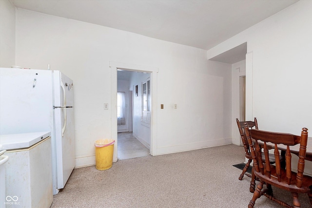 dining space featuring light carpet