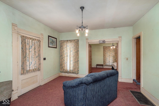 carpeted living room featuring a chandelier