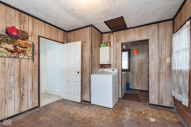 laundry room featuring dark parquet flooring, washer / dryer, a textured ceiling, and wood walls