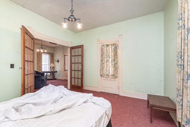 bedroom with an inviting chandelier, carpet, and french doors