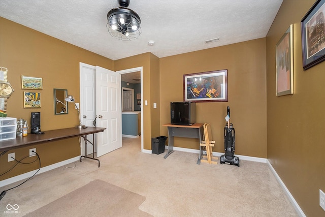 misc room featuring light colored carpet and a textured ceiling