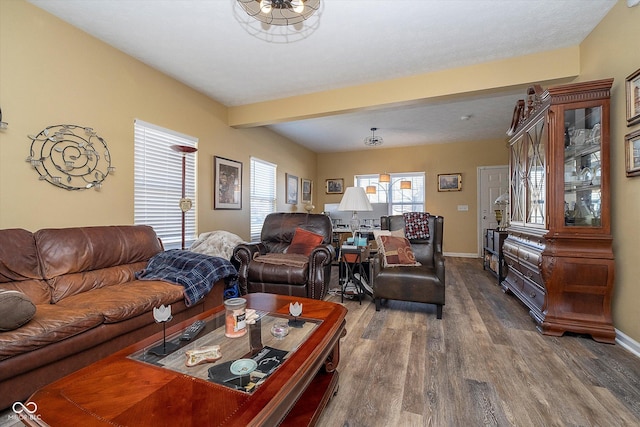 living room featuring beamed ceiling and dark hardwood / wood-style flooring