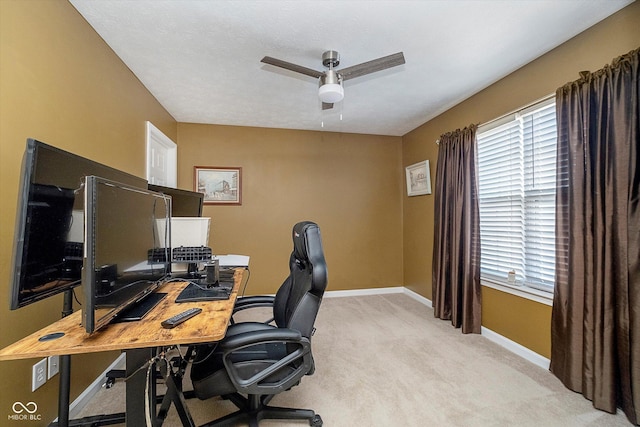 carpeted office space featuring plenty of natural light and ceiling fan