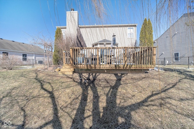 back of house featuring a wooden deck, central air condition unit, and a lawn