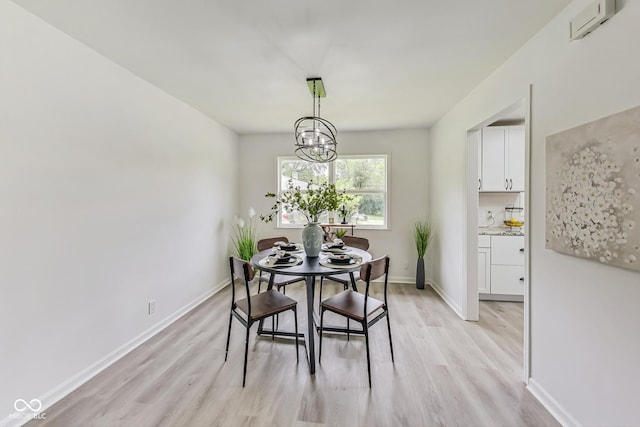 dining space with light hardwood / wood-style flooring and a notable chandelier