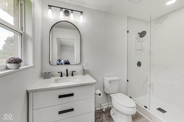 bathroom with vanity, wood-type flooring, a shower with shower door, and toilet