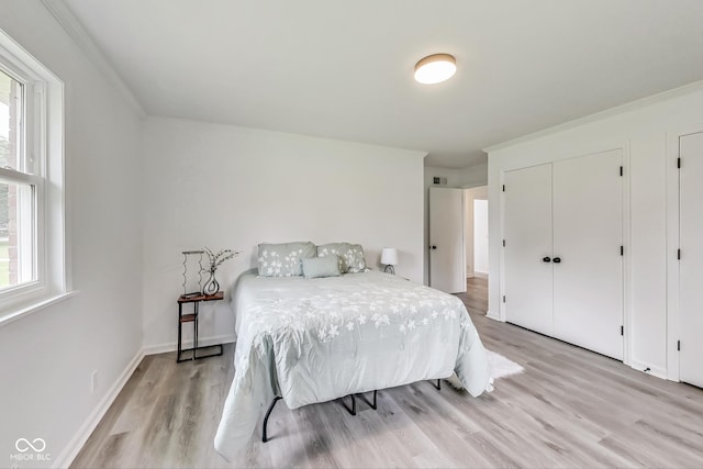 bedroom featuring ornamental molding and light hardwood / wood-style flooring