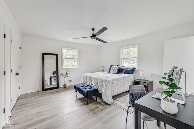 bedroom featuring ceiling fan, ornamental molding, and light hardwood / wood-style flooring