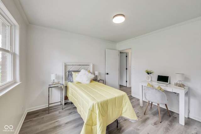 bedroom with wood-type flooring and ornamental molding